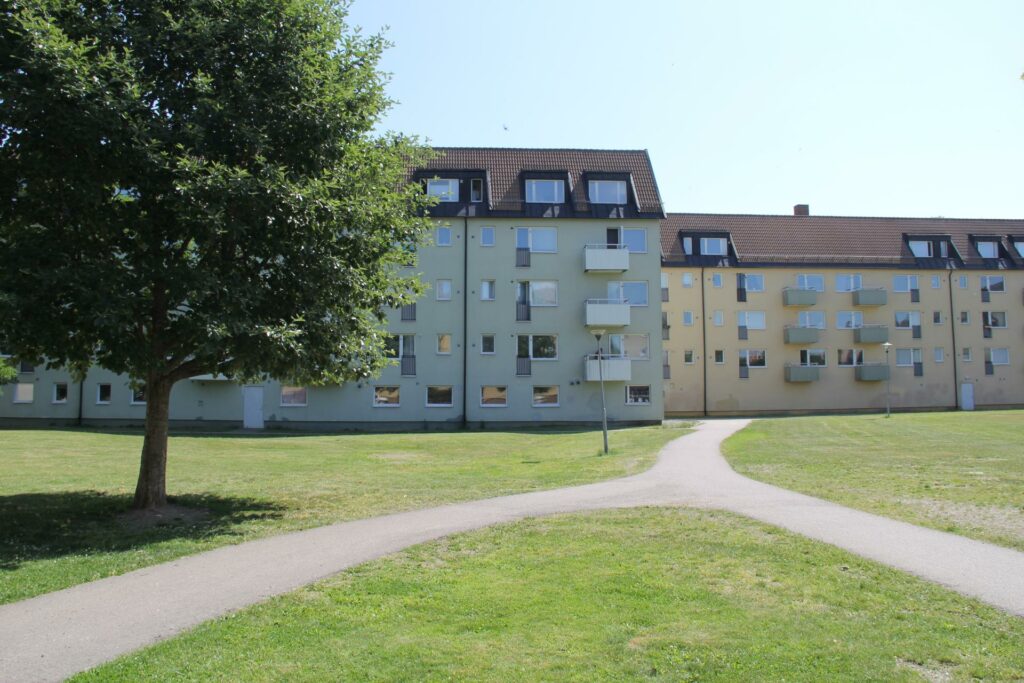 Cykelbana med grönytor bredvid och lägenhetshus runtom