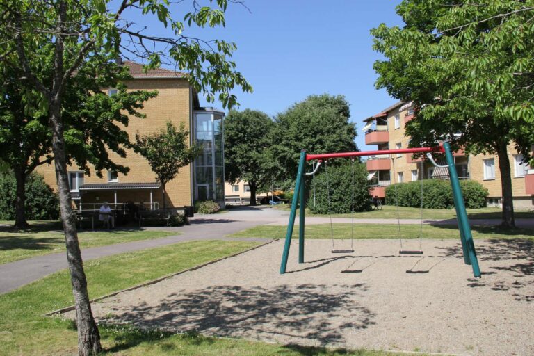 Lekpark med gungor mellan lägenhetshus