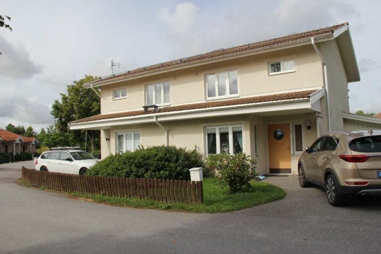 Tvåplats radhus med två parkerade bilar framför